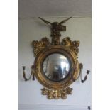 A VERY FINE REGENCY GILTWOOD AND GESSO GIRANDOLE CONVEX MIRROR surmounted by a winged eagle shown