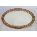 A 19TH CENTURY GILTWOOD AND GESSO MIRROR the oval plate within a reeded and ball decorated frame