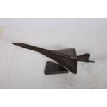 A CAST METAL FIGURE modelled as a Concorde raised on a moulded base 23cm (h) x 26cm (w) x 60cm (d)