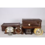 FOUR VINTAGE CLOCKS together with three suitcases