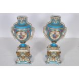 A PAIR OF CONTINENTAL PORCELAIN URNS each of ovoid tapering form the turquoise and gilt ground with