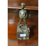 A BRONZED FIGURE modelled as a young boy skiing raised on a veined marble base 28cm