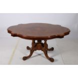 A 19TH CENTURY BURR WALNUT POD TABLE of serpentine outline the shaped top raised on ring turned