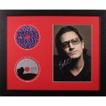 Bono, a signed photograph; framed together with two U2 CD's, frame 18" x 22" (46 x 56"cm).