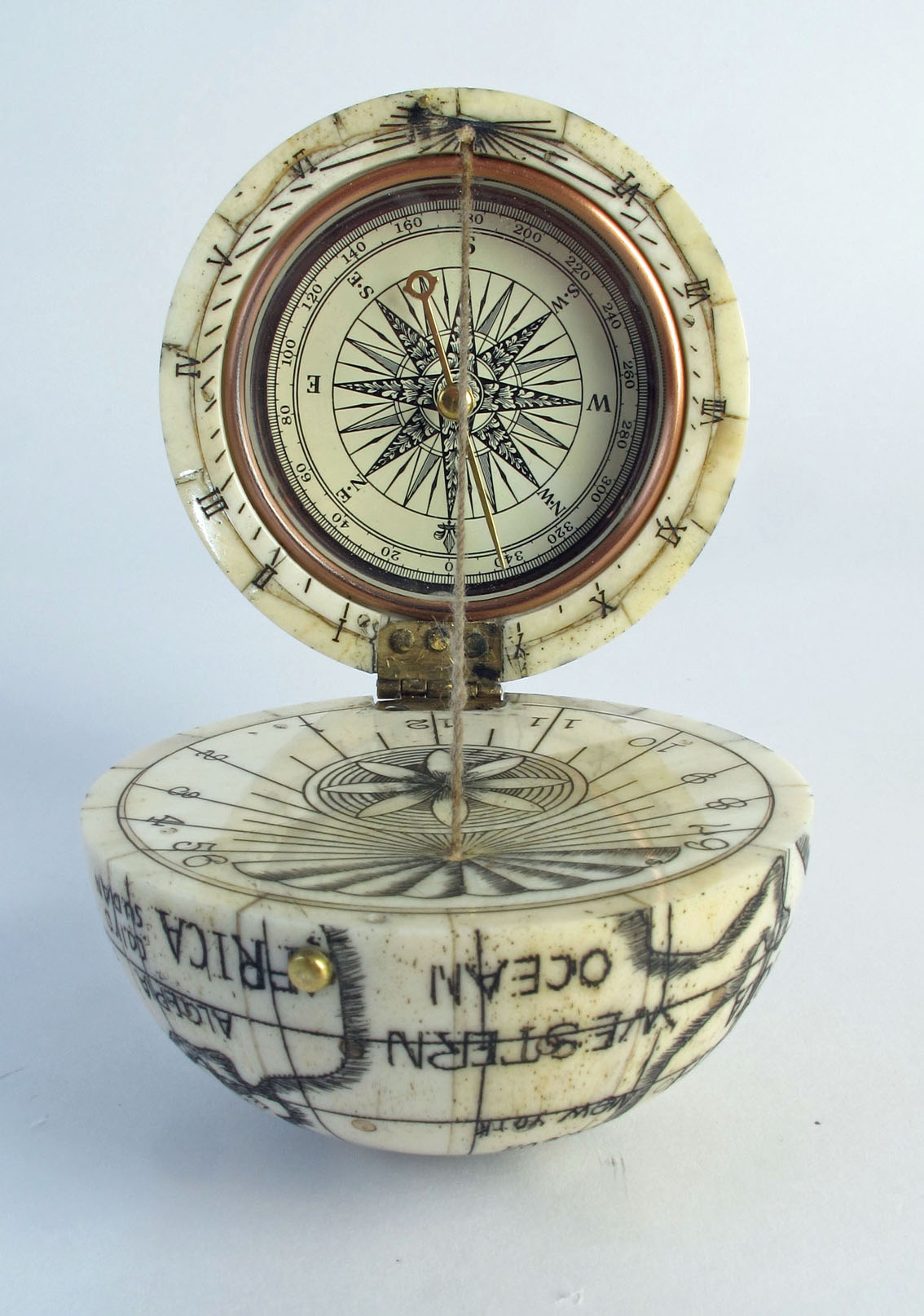 A scrimshaw style globe compass, the globe naively mapped,