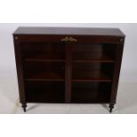 A REGENCY DESIGN MAHOGANY OPEN FRONT BOOKSHELF of rectangular outline the shaped top with a reeded