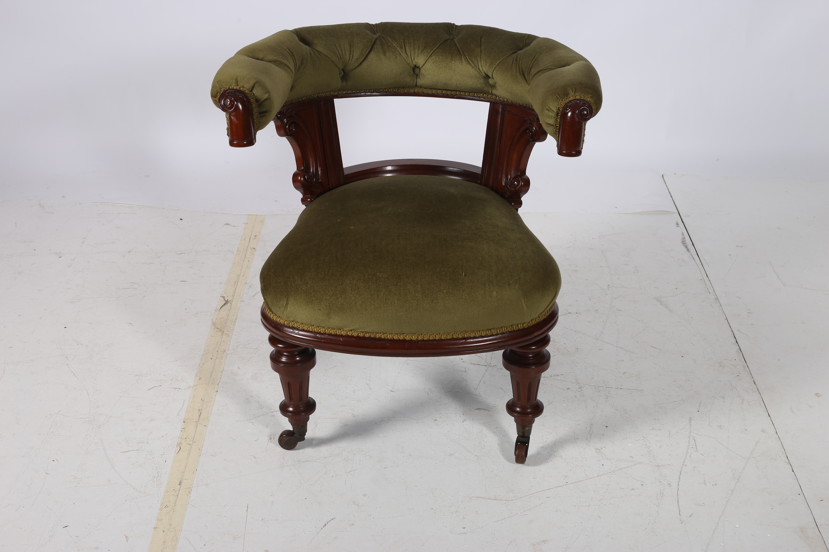 A 19TH CENTURY MAHOGANY AND UPHOLSTERED TUB SHAPED LIBRARY ARMCHAIR the button upholstered back and