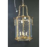 A GILT BRASS AND GLAZED FOUR LIGHT HALL LANTERN of circular form with pierced circlet hung with