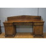 A 19TH CENTURY MAHOGANY SIDEBOARD of inverted breakfront outline the shaped top with moulded back