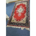 A TABRIZ WOOL RUG the wine ground with central foliate panel within an indigo border 166cm x 86cm