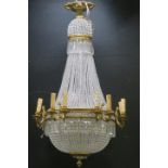 A CONTINENTAL GILT BRASS AND CUT GLASS BASKET CHANDELIER with cascading pendent drops and faceted