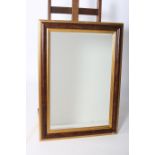 A SIMULATED WALNUT AND GILTWOOD MIRROR the rectangular bevelled glass plate within a moulded frame