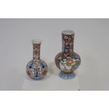 TWO ORIENTAL VASES each of bulbous form the white ground decorated with stylized flowerheads and