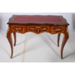 A CONTINENTAL KINGWOOD SATINWOOD INLAID AND GILT BRASS MOUNTED WRITING TABLE of serpentine outline