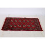 AN AFGHAN BARGESTA WOOL RUG the wine ground with central panels filled with hooks and palmettes