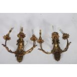 A PAIR OF CONTINENTAL GILT BRASS FOUR BRANCH WALL LIGHTS with foliate scroll arms and back plate