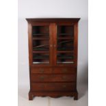 A GEORGIAN MAHOGANY CABINET the dentil moulded cornice above a pair of glazed doors containing