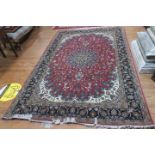 A TABRIZ WOOL RUG the wine ground with central panel filled with stylized flowerheads foliage and