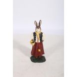 A CAST IRON AND POLYCHROME FIGURE modelled as a rabbit dressed as a female shown standing on a