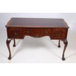 A CHIPPENDALE DESIGN MAHOGANY DESK of serpentine outline the shaped top with gadrooned rim and