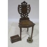 A CARVED WOOD HALL CHAIR the shield shaped and pierced back above a shaped seat on carved legs