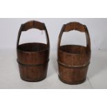A PAIR OF HARDWOOD AND STEEL BOUND PAILS of cylindrical tapering form with carrying handles 60cm