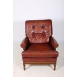 A GOOD WALNUT AND HIDE UPHOLSTERED LIBRARY ARMCHAIR with loose cushions and button upholstered back