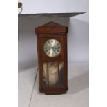 A RETRO OAK CASE WALL MOUNTED CLOCK the bevelled glass and moulded door containing a silvered dial