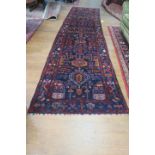 A FINE AFGHAN WOOL RUNNER the indigo wine and dark blue ground the central panel filled with