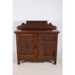 A 19TH CENTURY CARVED OAK SIDE CABINET of rectangular outline with carved back above three frieze