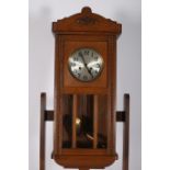 A CIRCA 1950s OAK CASE WALL CLOCK the moulded frame with bead work decoration and glazed panels