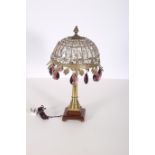 A BRASS CUT GLASS TABLE LAMP the dome shaped shade with faceted drops hung with topaz glazed
