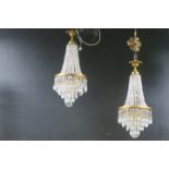 A PAIR OF CONTINENTAL CUT GLASS AND GILT BRASS CHANDELIERS with cascading pendents above a foliate