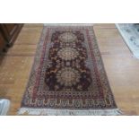AN ORIENTAL WOOL RUG the light and dark brown ground with central panel filled with stylized