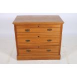 AN EDWARDIAN SATIN BIRCH CHEST of rectangular outline with three frieze drawers and brass drop