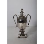 A 19TH CENTURY SILVER PLATED SAMOVAR of urn form with scroll handles embossed with flower heads and