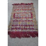 A BERBER MOROCCAN RUG the wine ground with serrated and diamond shaped panels with sequins 155cm x