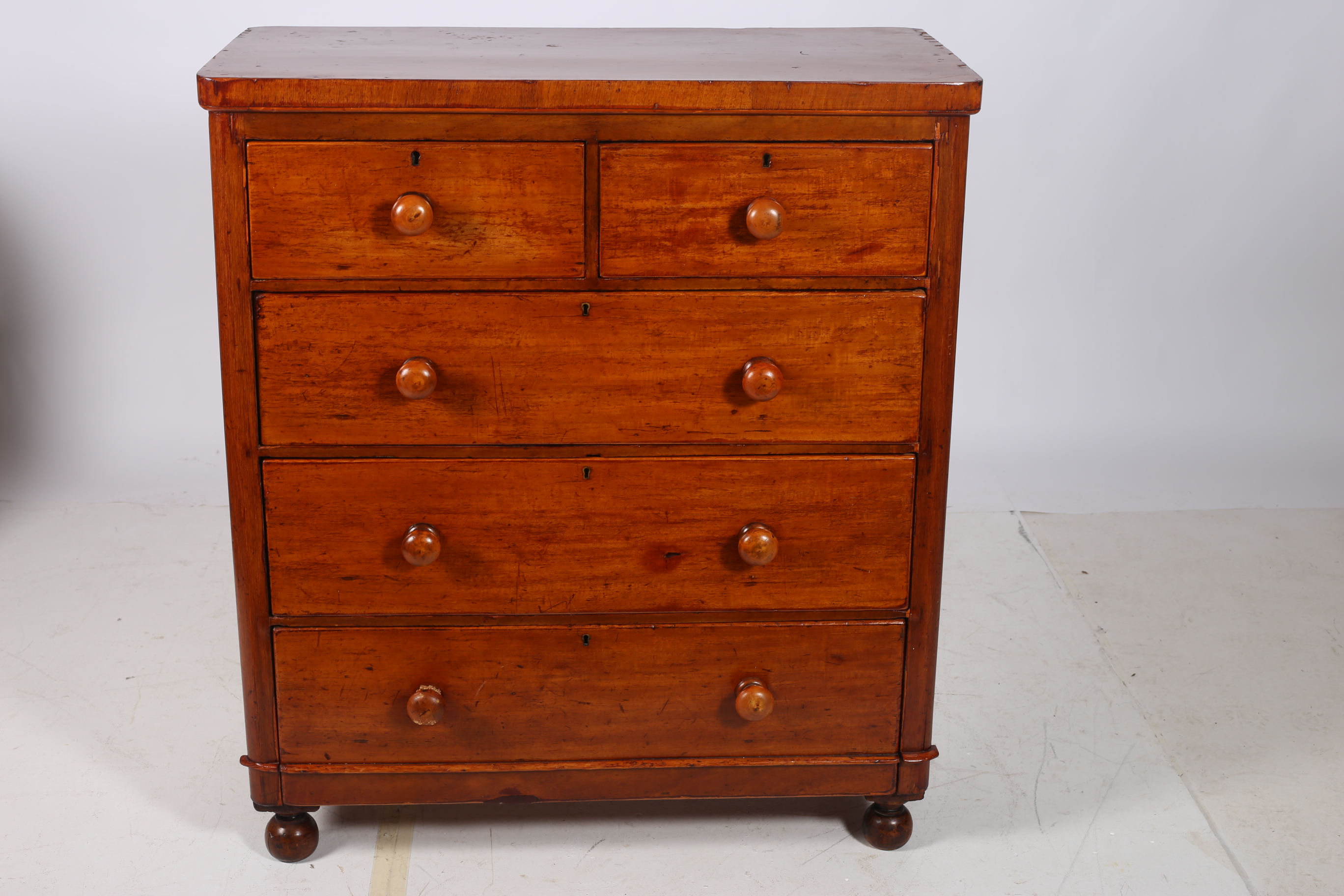 A 19TH CENTURY MAHOGANY CHEST of rectangular outline with two short and three long drawers on bun