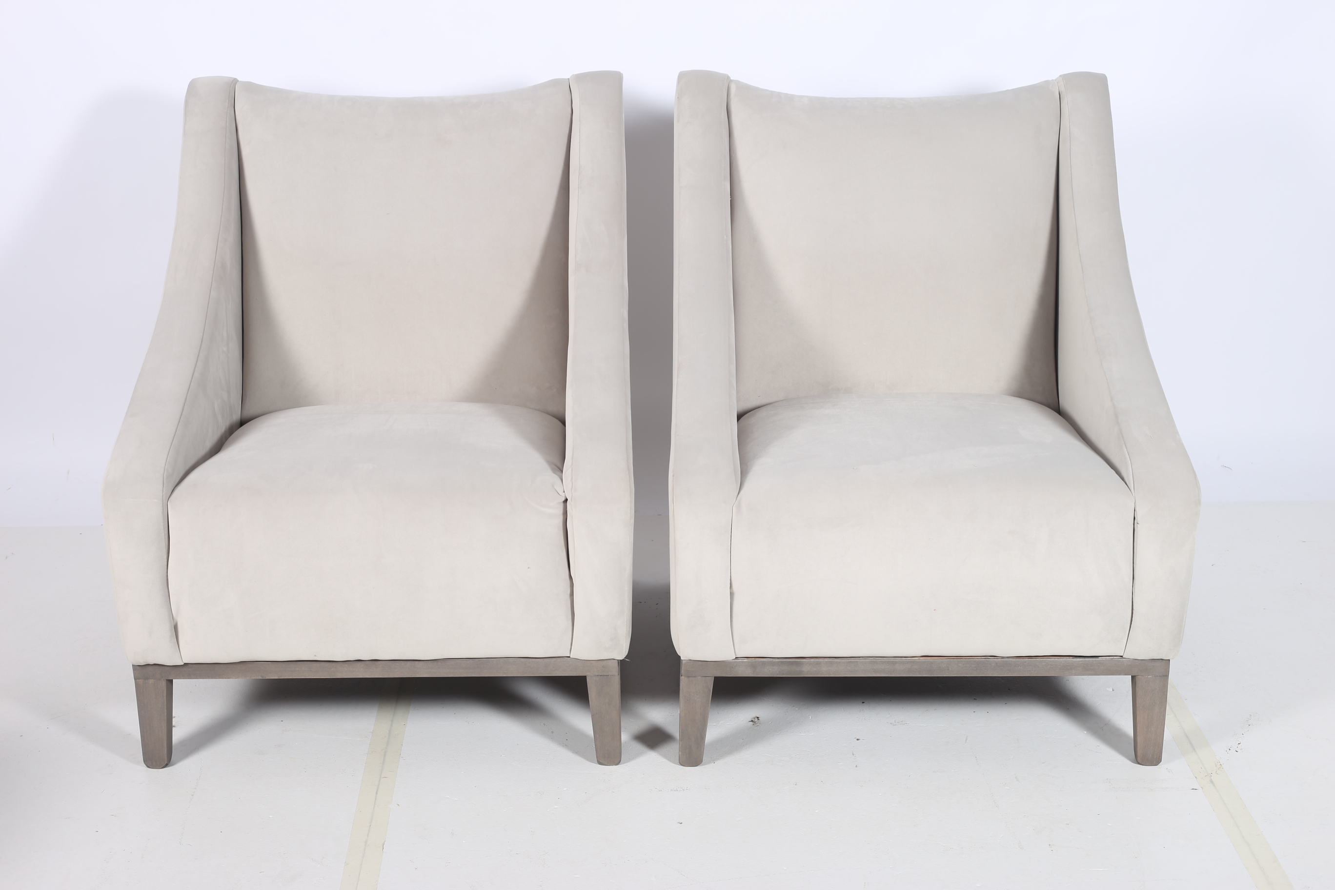 A PAIR OF RETRO EASY CHAIRS each with a shaped back and curved arms on square moulded legs en-suite