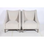 A PAIR OF RETRO EASY CHAIRS each with a shaped back and curved arms on square moulded legs en-suite