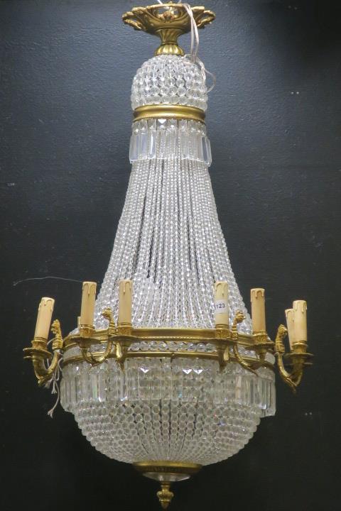 A CONTINENTAL GILT BRASS AND CUT GLASS BASKET CHANDELIER with cascading pendent drops and faceted