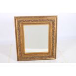 A CONTINENTAL GILT FRAMED MIRROR the rectangular bevelled glass plate within a foliate moulded