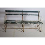 A WROUGHT IRON AND PINE SEAT with slatted back and seat with scroll arms on conforming legs 150cm