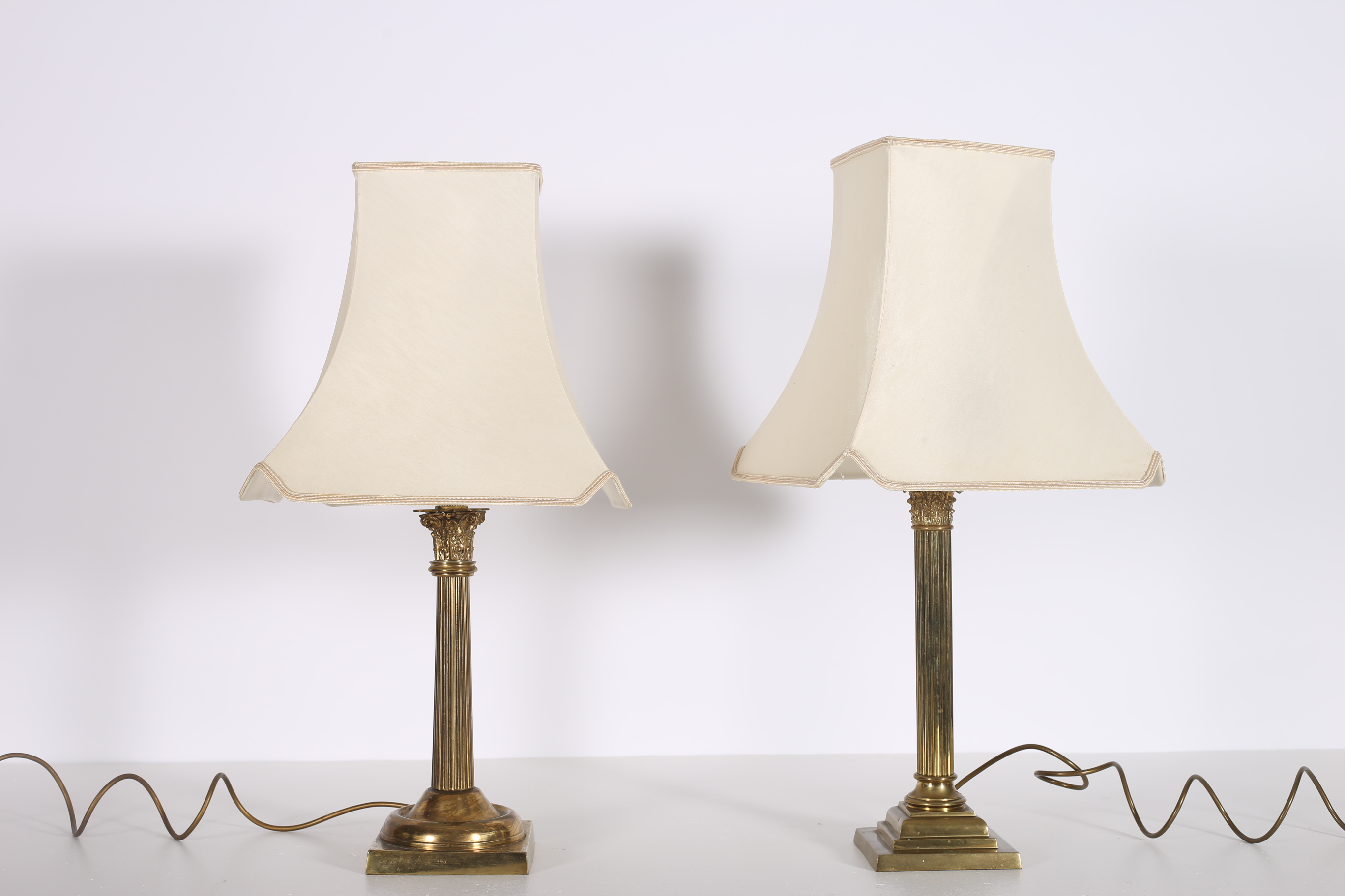 TWO 19TH CENTURY BRASS TABLE LAMPS each with a reeded column and Corinthian capital raised on a