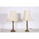 TWO 19TH CENTURY BRASS TABLE LAMPS each with a reeded column and Corinthian capital raised on a