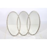 A CONTINENTAL SILVER FRAMED MIRROR of oval intertwined outline 88cm x 108cm