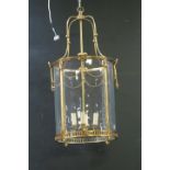 A GILT BRASS AND GLAZED FOUR LIGHT HALL LANTERN of circular form with pierced circlet hung with
