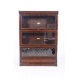 A RETRO OAK STACKING LIBRARY BOOKCASE of rectangular outline with sliding glazed lead and glass