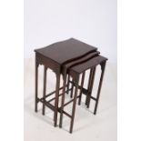 A NEST OF THREE ROSEWOOD TABLES each of serpentine outline the shaped top raised on moulded legs