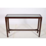 A ROSEWOOD CONSOLE TABLE of rectangular outline with bevelled glass inset raised on square tapering